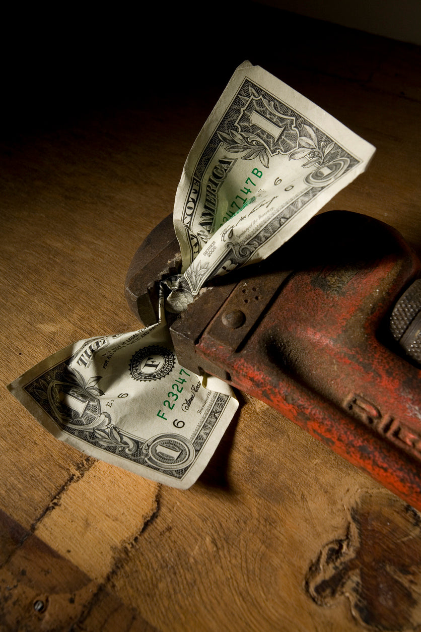 Pipe Wrench Tightened on Dollar Bill